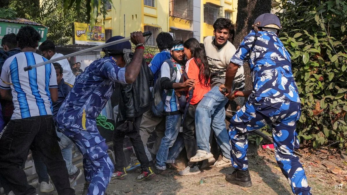 Messi in Kolkata: Chaotic street scene showing uniformed personnel confronting distressed civilians near a yellow building.